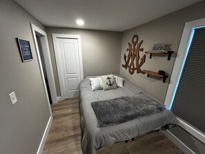 Queen bedroom with dresser and 50” smart tv