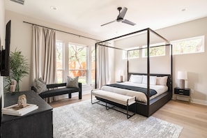 Cozy and luxe Restoration Hardware bed with smart TV and luxury linens.
