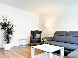 Wohnzimmer mit Ecksofa und Sessel