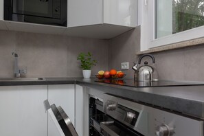 Kitchenette with plenty of kitchen utensils and dishes. 