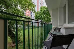 Furnished balcony with green surroundings. 