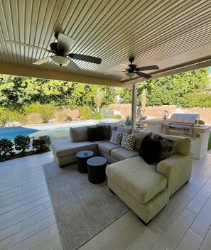 Outdoor living space with built in BBQ, tv and two new fans overhead 