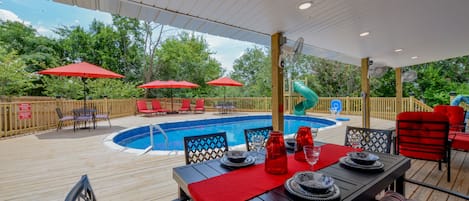 The Backyard - There is plenty to do at Bama Cottage! Out in the back there is a pool and water slide. There's also sun lounging chairs and a covered area for dining and grilling out.