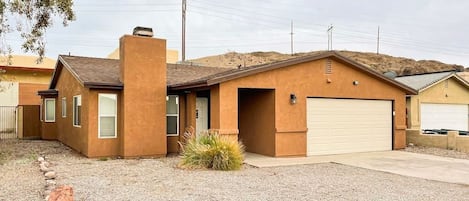 The front view of the house presents a welcoming facade and tons of parking for guests.