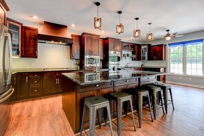 Large well stocked kitchen with lots of counter spaces and multiple sinks.