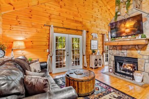 [Living Room] Bright, open living room with vaulted ceilings, gas fireplace, and sleeper sofa—ideal for cozy nights or movie marathons.