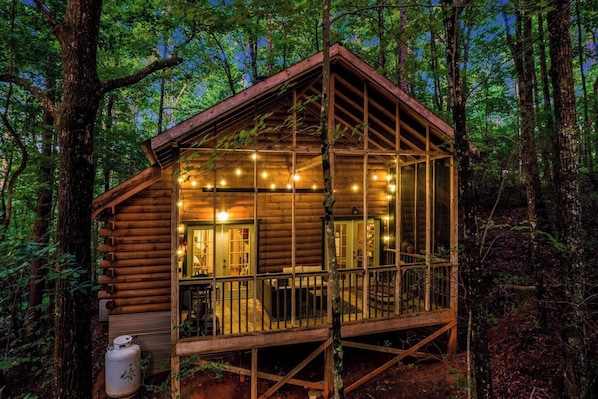 [Back Deck] Enjoy a private screened deck with twinkle lights, gas grill, and peaceful wooded views—perfect for evening relaxation.