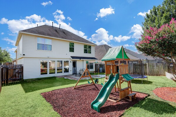 Backyard with playground and trampoline,BBQ grill and outdoor dining set