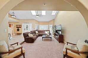 Living room with sectional couch and 75 inch TV