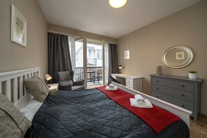 Bedroom 2 with balcony, double bed, wardrobe and work desk 