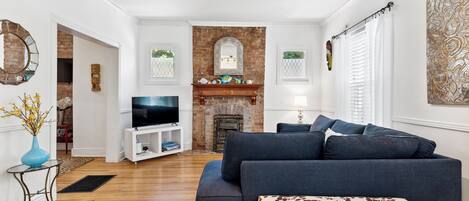 Spacious living room with a large comfy L-shape sofa and smart tv