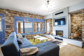 Salon avec cheminée et vue sur la mer