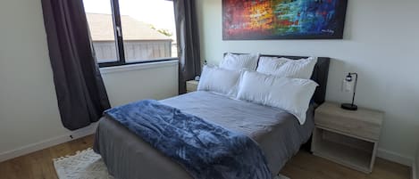 Queen bed with blackout curtains in bedroom