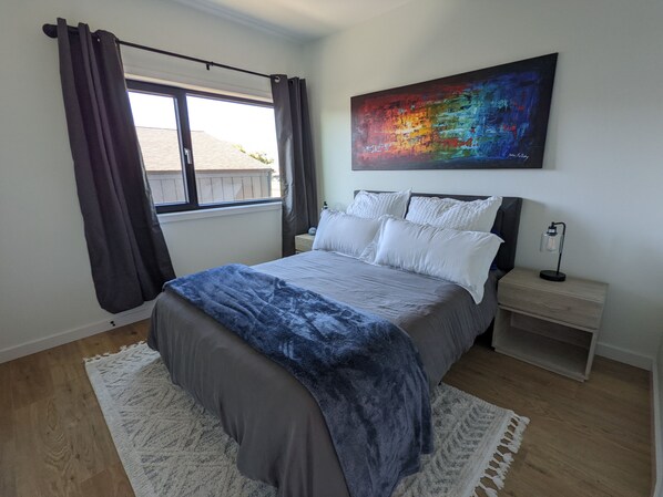 Queen bed with blackout curtains in bedroom