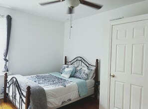 Queen bed with fresh linens in a room full of natural light and full closet. 