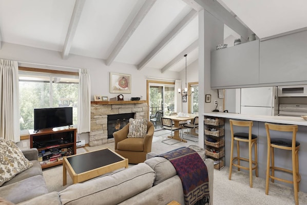 The open floor plan, vaulted ceilings and large windows and sliding door create a very inviting space to vacation.