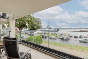 A spacious balcony with a table and chairs, offering a panoramic view.

