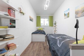 A view of second bedroom, highlighting decorative shelves and a cozy reading nook.
