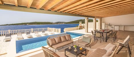 Dining terrace with summer kitchen and BBQ overlooking the pool