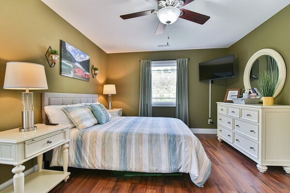 Master bedroom upstairs with queen size bed and mounted TV