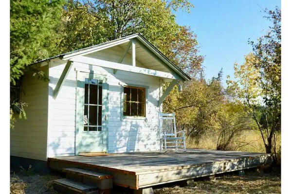 The Angler cabin sits riverside, has a private deck and table, two chairs