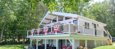 Large expansive deck with lower level patio featuring floor to ceiling windows 