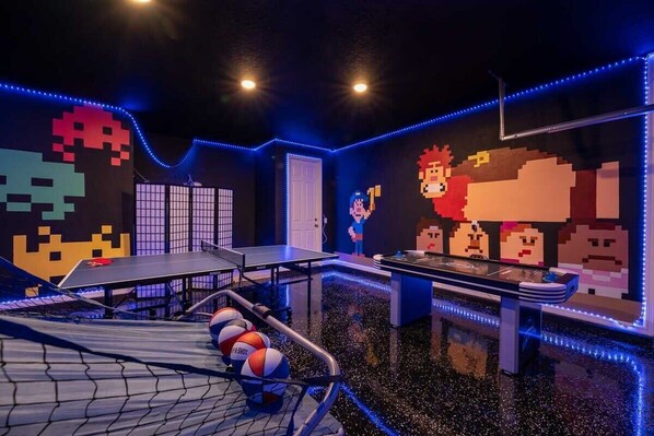 Unleash your inner gamer in this vibrant game room with ping pong, air hockey, and retro pixel art!