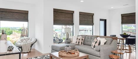 Bright and spacious living room that opens to the kitchen. The couch turns into a sleeper sofa. Custom blackout blinds. Smart TV equipped with YouTube TV for cable.