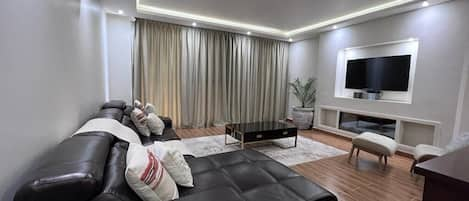 Spacious living room with Dstv satellite TV and Netflix streaming.