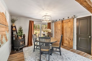 Dining for 4, barn doors leading to the laundry, and decorative pellet stove