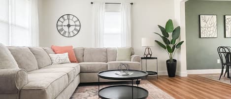 The bright and cheery living room is open to dining area and kitchen.