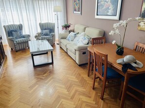 Salón con cómodo sofá y dos butacas, TV con WiFi y Mesa de comedor extensible.