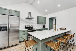 Gorgeous kitchen with granite counters, new cabinets, stainless appliances, tile backsplash, and modern fixtures