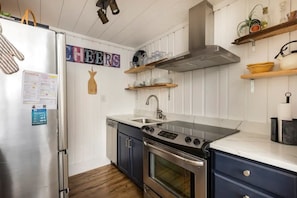 Stocked kitchen with updated stainless steel appliances.