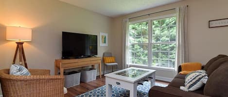 Living room with large flat screen TV, foosball table coffee table, and queen size sleeper sofa