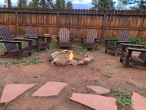 Wood burning fire pit with 6 Adirondack chairs for s'mores or star gazing.