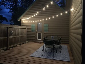 Deck off the kitchen features a dining table and gas BBQ grill.