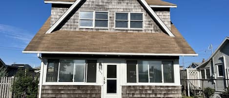 Front of home with center sidewalk going into sunroom/enclosed screened porch.