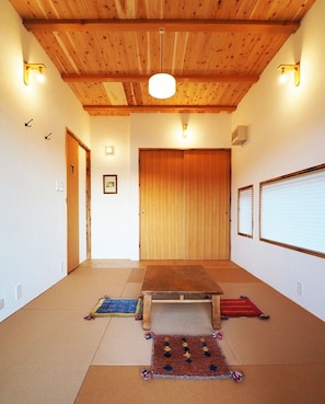 Bedroom 1. We aimed to create a dynamic mountain hut-like atmosphere by exposing the ceiling and bringing out the flavor of the wood. Up to 4 people can sleep on futons.