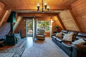 Living room with wood-burning fireplace and beautiful A-frame beams