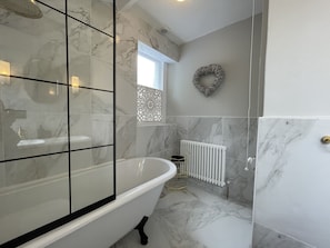 The bathroom comprises bath with overhead waterfall shower, sink and WC