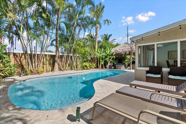 Relax poolside in the sparkling heated pool with lush landscaping in South Florida's sunny weather.