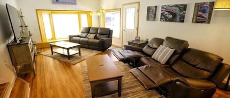 Living Room with large screen TV, power recliners, and decorative artwork from all around Southeast Alaska. 