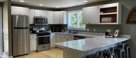 Kitchen stocked with pots & pans, coffee maker, dishes, and a lobster pot.