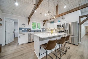 Kitchen has a large center island with 3 stools. 