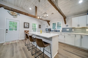 Kitchen has a large center island with 3 stools. 