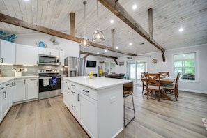 Kitchen has a large center island with 3 stools. 