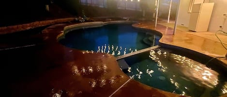 Pool with solar lights lit up at night.