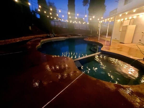 Pool with solar lights lit up at night.