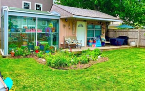 Backyard garden oasis. Fish pond with 2 more patios & glass greenhouse backdrop.